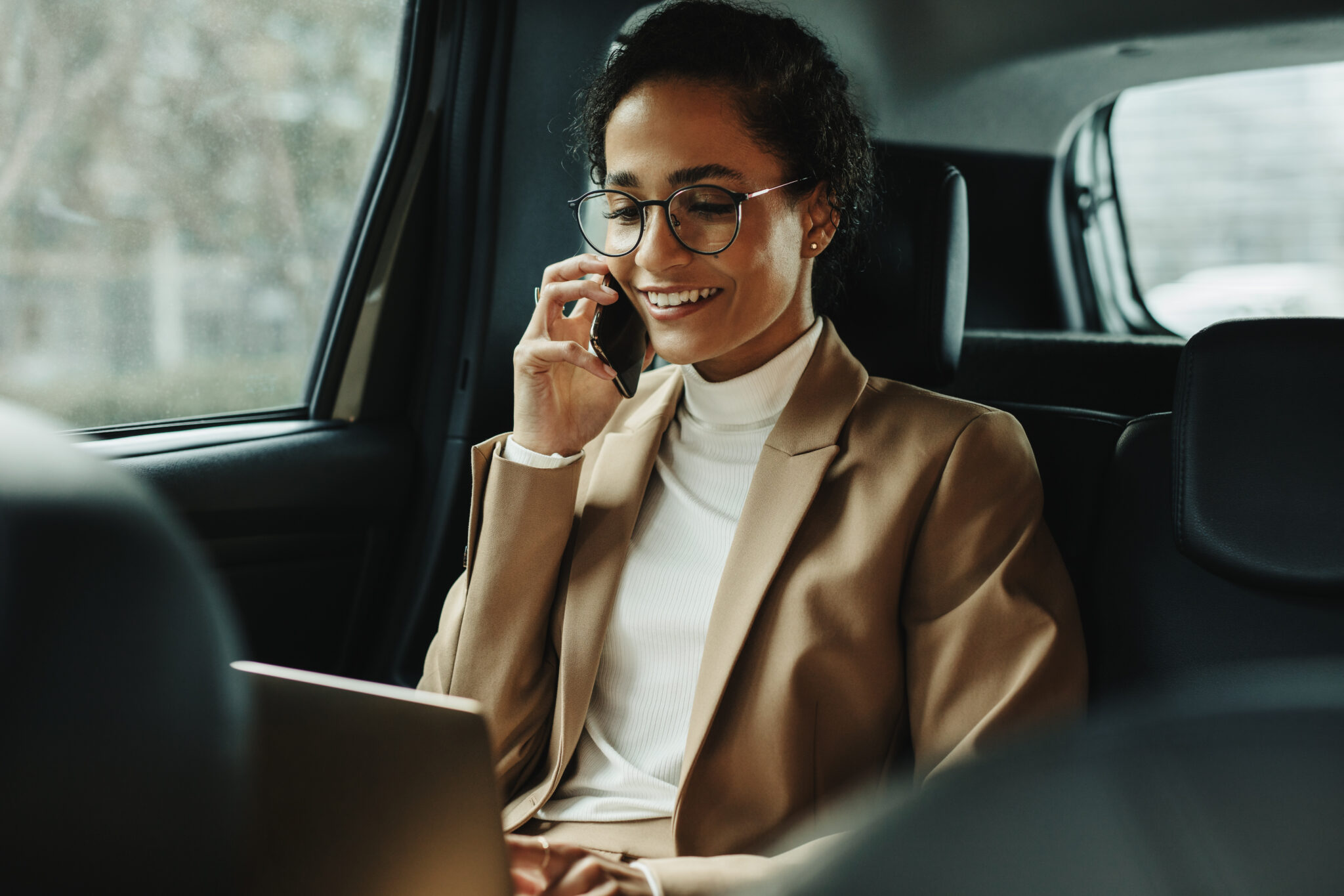 Businesswoman,Working,On,Laptop,And,Talking,On,Phone,While,Travelling