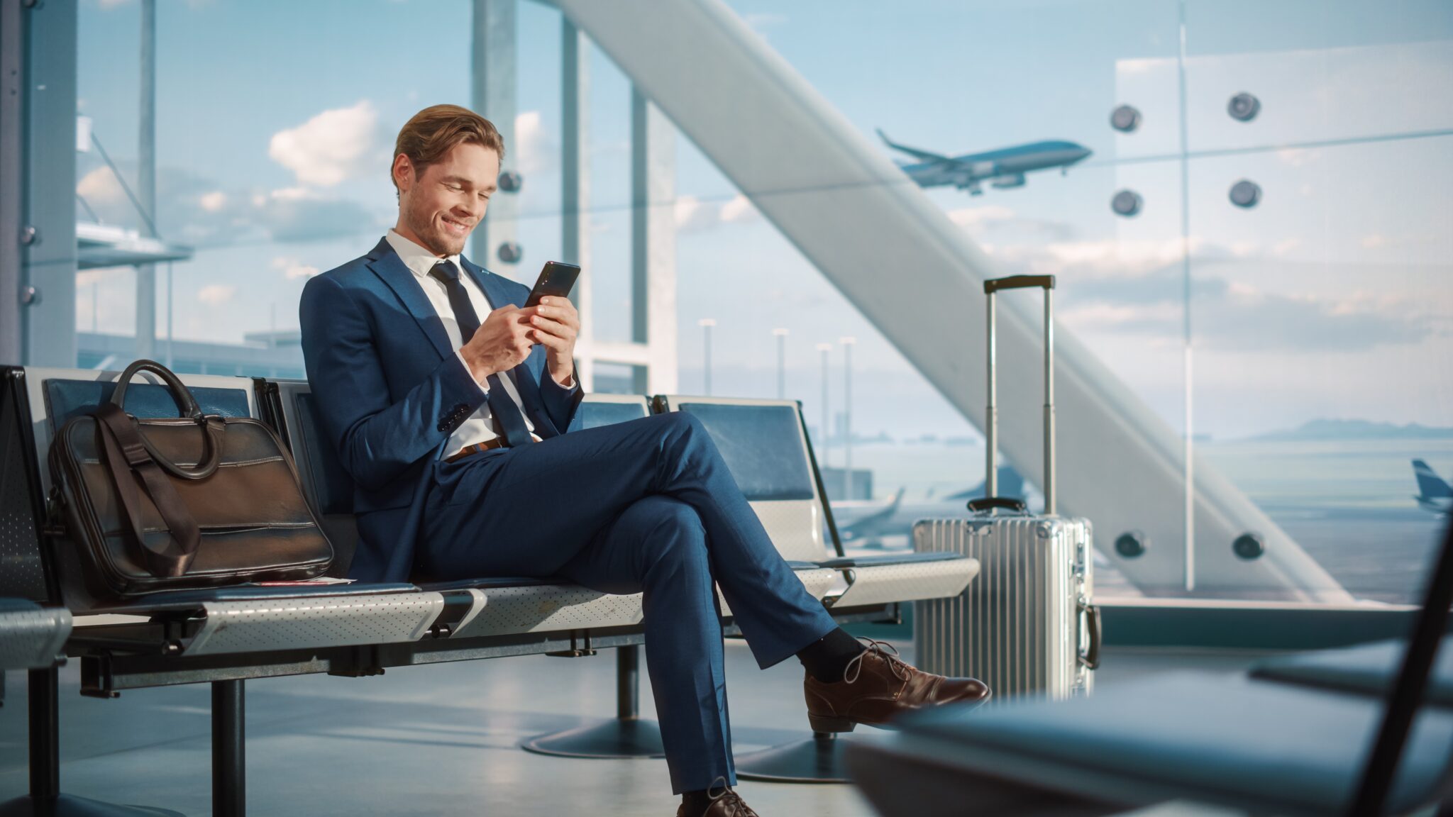 Airport,Terminal,Flight,Wait:,Smiling,Businessman,Uses,Smartphone,For,E-business,